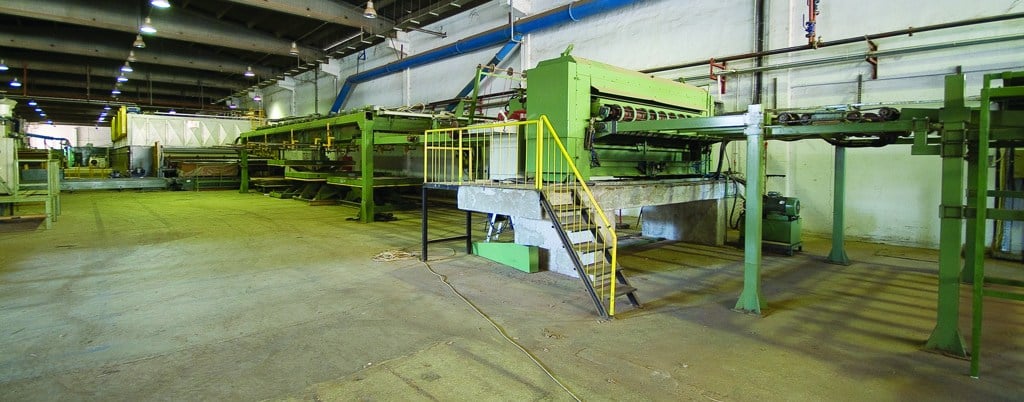 A long lumber production line with green machinery inside the Bahar factory